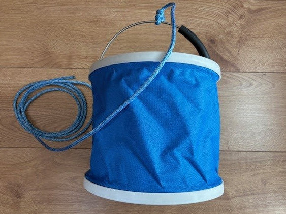 Expanded blue PVC folding bucket with raised metal handle and coiled blue lanyard