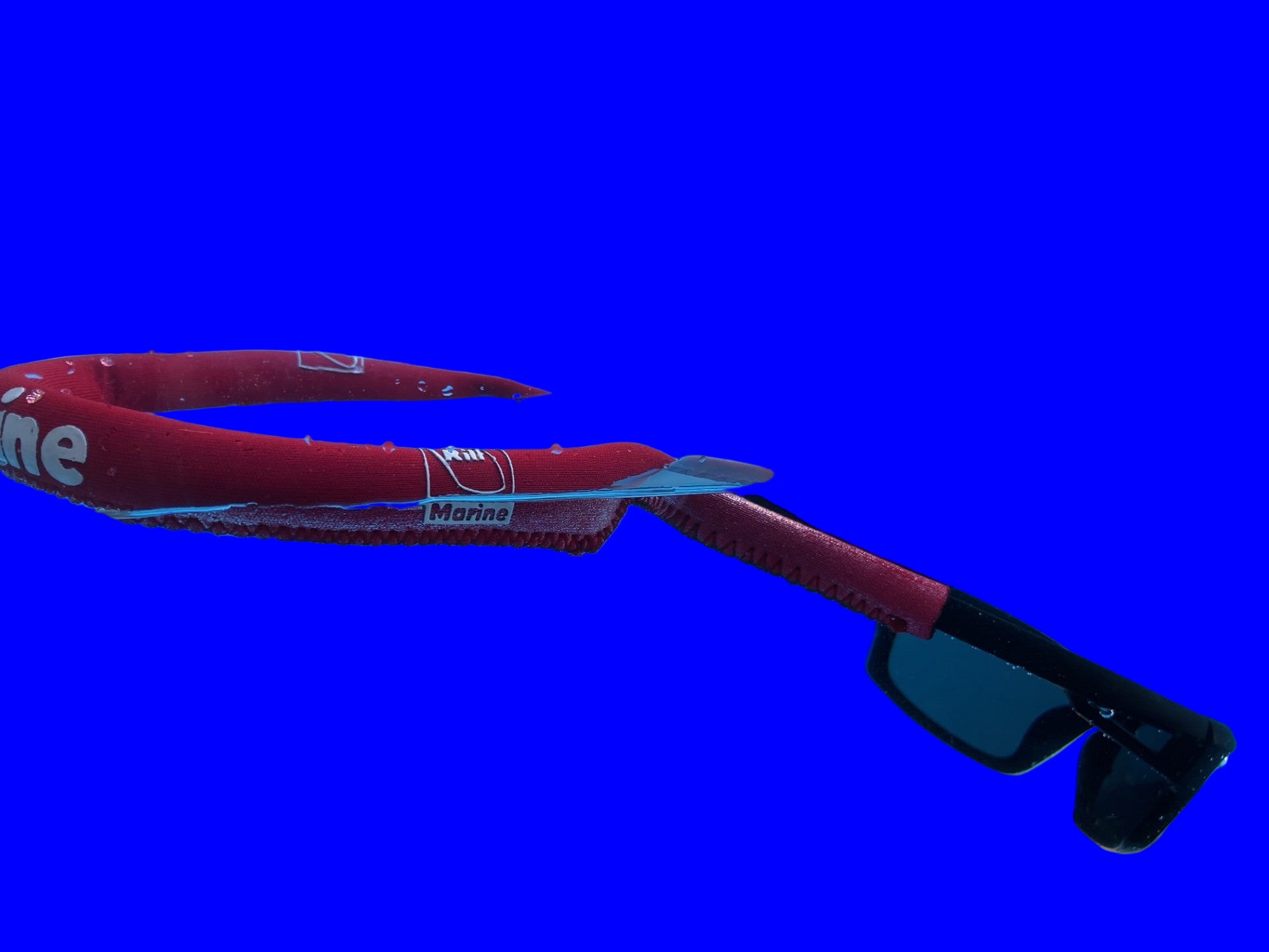 Neoprene floating red strap keeping sunglasses afloat in water