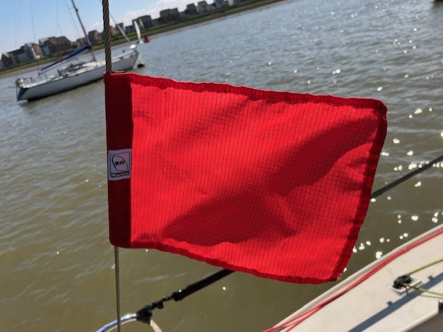 Red pennant-style sailing protest flag on backstay